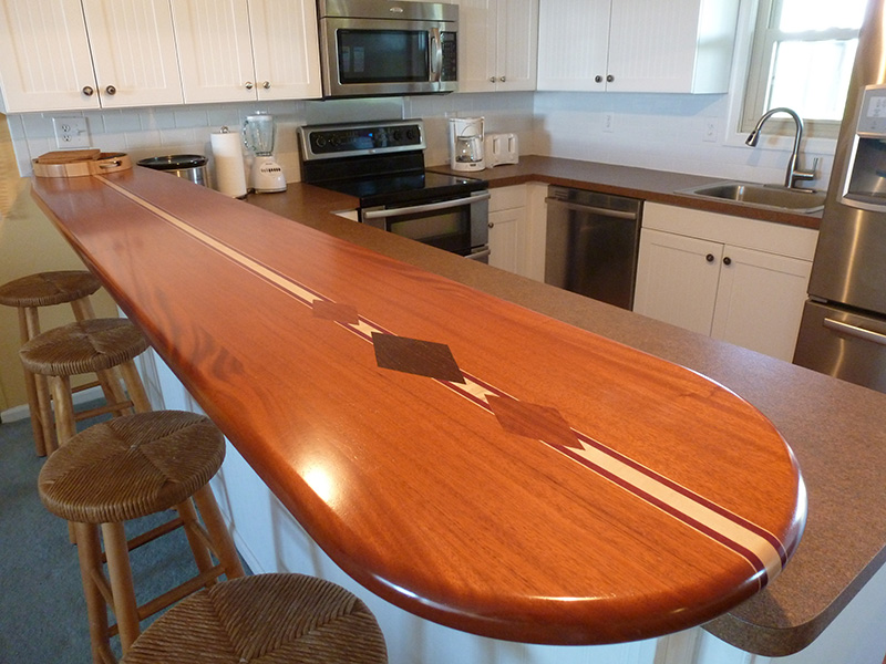 1.5" thick surfboard countertop with 1.5" bullnose edge treatment, diamond inlays, and permanent finish. Woods used included - African mahogany, hard maple, purpleheart, wenge, and paduak.