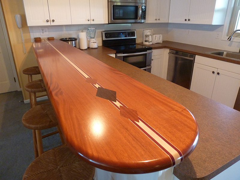 1.5" thick surfboard countertop with 1.5" bullnose edge treatment, diamond inlays, and permanent finish.  Woods used included - African mahogany, hard maple, purpleheart, wenge, and paduak.